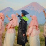 a group of people standing next to each other in front of a mountain